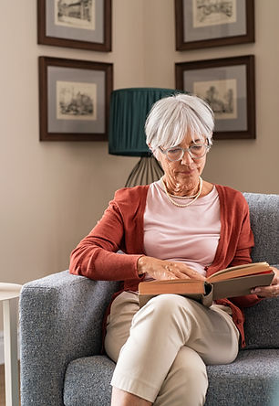 Stock lifestyle photograph of an older woman reading at home; not a Kingdom Forge resident